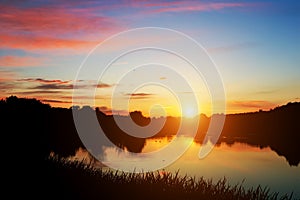 Lake in forest at sunset. Romantic sky