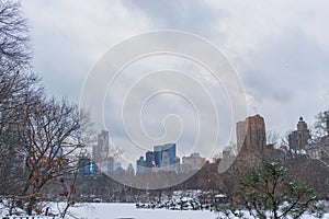 Lake in frozen central park with view of city in background, New York.