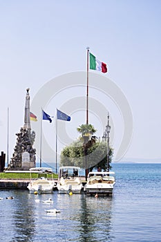 Lake of Garda. the port of the beautiful town of Lazise with modern toutistic boars and historical buildings photo