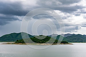 Lake and green hills in Kaeng Krachan National Park on a cloudy day. Thailand.
