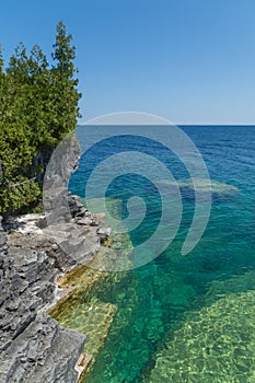 Lake Huron shoreline blue green water and limestone rocks along