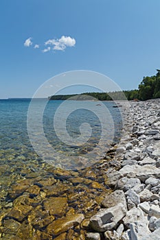 Lake Huron shoreline blue green water and limestone rocks along