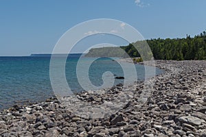 Lake Huron shoreline blue green water and limestone rocks along