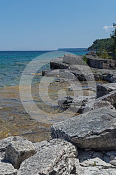 Lake Huron shoreline blue green water and limestone rocks along