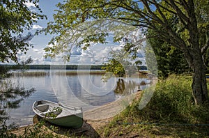 Lake landscape in Finland, boat and beach