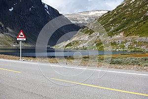 Lake landscape with scenic road and moose sign