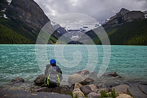 Lake Louise, Banff National Park, Alberta, Canada. Backpack hiker looks on amazing landscape. Active life.