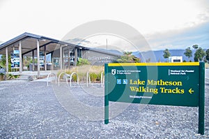 Lake Matheson walking tracks sign at the entrance, leads to views of the mountains reflected on the still waters of Lake Matheson.