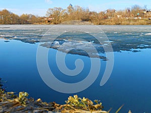 Lake with melting ice in clear day.