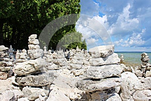 The Lake Michigan shoreline covered with cairns backed by a row of trees in Point County Park, Door County, Wisconsin