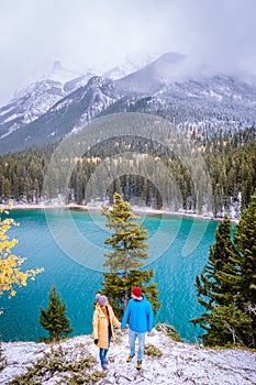 Lake Minnewanka Banff national park Canada, couple walking by the lake during snow storm in October in the Canadian