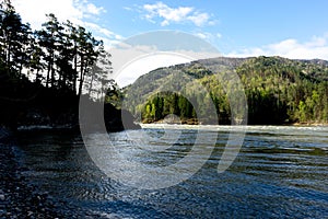 Lake in the mountains	covered with green trees