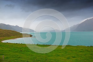 Lake, mountains and nature with view of green scenery on foggy or misty morning outdoor in spring. Earth, sky and water