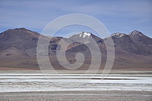 Lake between the mountains, with pink flamingo. Off-road tour on the salt flat Salar de Uyuni in Bolivia