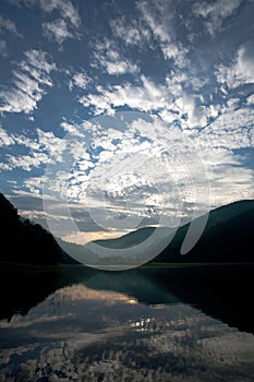 Lake in the mountains in reflection of the dawn sky