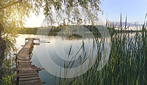 Lake panorama with fishing pier at sunset