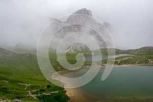 Lake Piano in the fog with amazing turquoise color of water. The mountain lake in the Dolomites. Italy