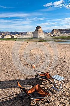 Lake Powell - Two camping chairs and one table set up at Lone Rock Beach campground with scenic view of Wahweap Bay