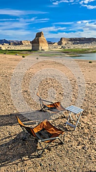 Lake Powell - Two camping chairs and one table set up at Lone Rock Beach campground with scenic view of Wahweap Bay