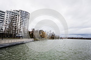 Lake promenade with glass building multistorey residental house on background