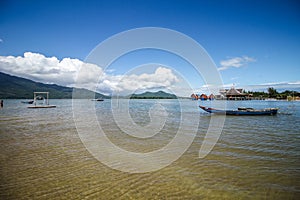 Lake resort at Lang Co in Vietnam with boats and huts under a blue sky