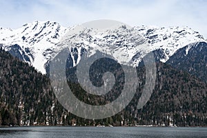 Lake Ritsa in Abkhazia in spring. The mountain tops are covered with snow. The beginning of the tourist season.