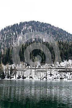 Lake Ritsa in Abkhazia in spring. The mountain tops are covered with snow. The beginning of the tourist season.