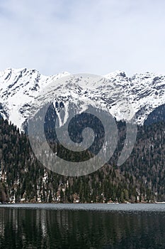 Lake Ritsa in Abkhazia in spring. The mountain tops are covered with snow. The beginning of the tourist season.