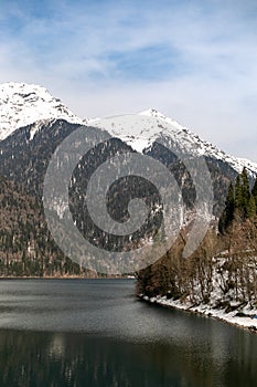 Lake Ritsa in Abkhazia in spring. The mountain tops are covered with snow. The beginning of the tourist season.