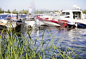 green grass lake water sunlight boats sky summer day bokeh background outdoor