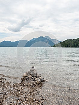 Lake shore. Balanced stones stack. Near Alps peak