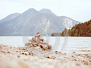 Lake shore. Balanced stones stack. Near Alps peak