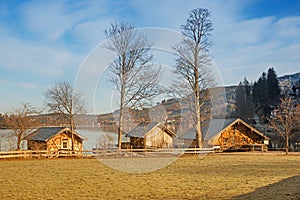 Lake shore south of Schliersee, wooden boathouses Fischhausen and bare leaved trees