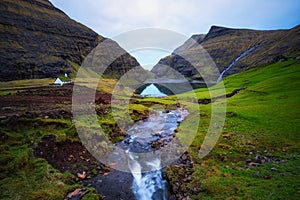 Lake and a small white church in Saksun on the Faroe islands, Denmark.