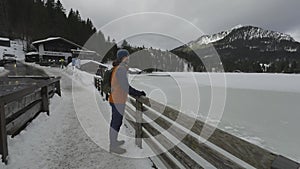 Lake Spitzingsee in winter covered with snow and ice in freezing cloudy weather in Bavaria, Germany. A mountain lake in