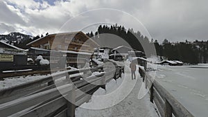 Lake Spitzingsee in winter covered with snow and ice in freezing cloudy weather in Bavaria, Germany. A mountain lake in