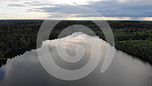 Lake in spring sunset 4k aerial top view. Fly above water of lake Dolgoe, Belarus