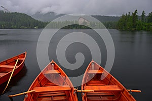 Lake StrbskÃ© pleso and a hotel in the High Tatras, Slovakia. Orange boats in front. The ski-jumping hill on the left. It`s