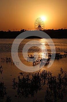 Lake at sunset and amusement park in the background
