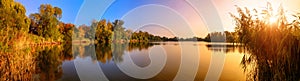 Lake sunset panorama in gold and blue