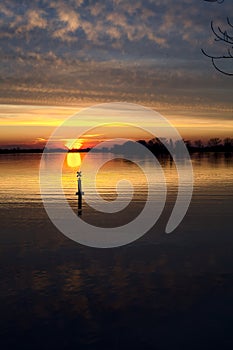 Lake at sunset with the sky casted in the water seen from the shore