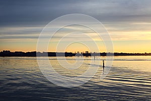 Lake at sunset with the sky casted in the water seen from the shore