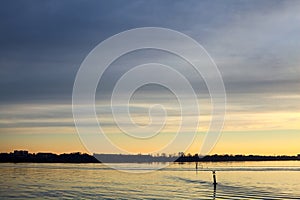 Lake at sunset with the sky casted in the water seen from the shore