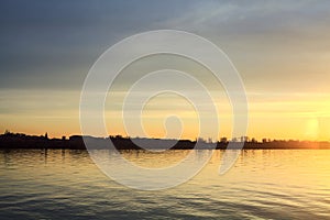 Lake at sunset with the sky casted in the water seen from the shore