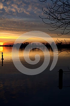 Lake at sunset with the sky casted in the water seen from the shore