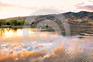 Lake with sunset sky reflection, and houses and foothills in the distance Snake River on the border of Idaho and Washington states