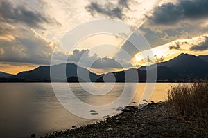 Lake surroundeb by wooded mountains at Sunset