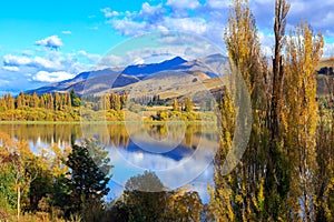 Lake surrounded by autumn trees and mountains. Otago, New Zealand