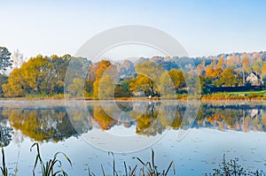 The lake is surrounded by autumn trees reflected in the mirror surface of the lake