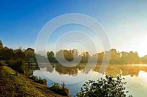 The lake is surrounded by autumn trees reflected in the mirror surface of the lake